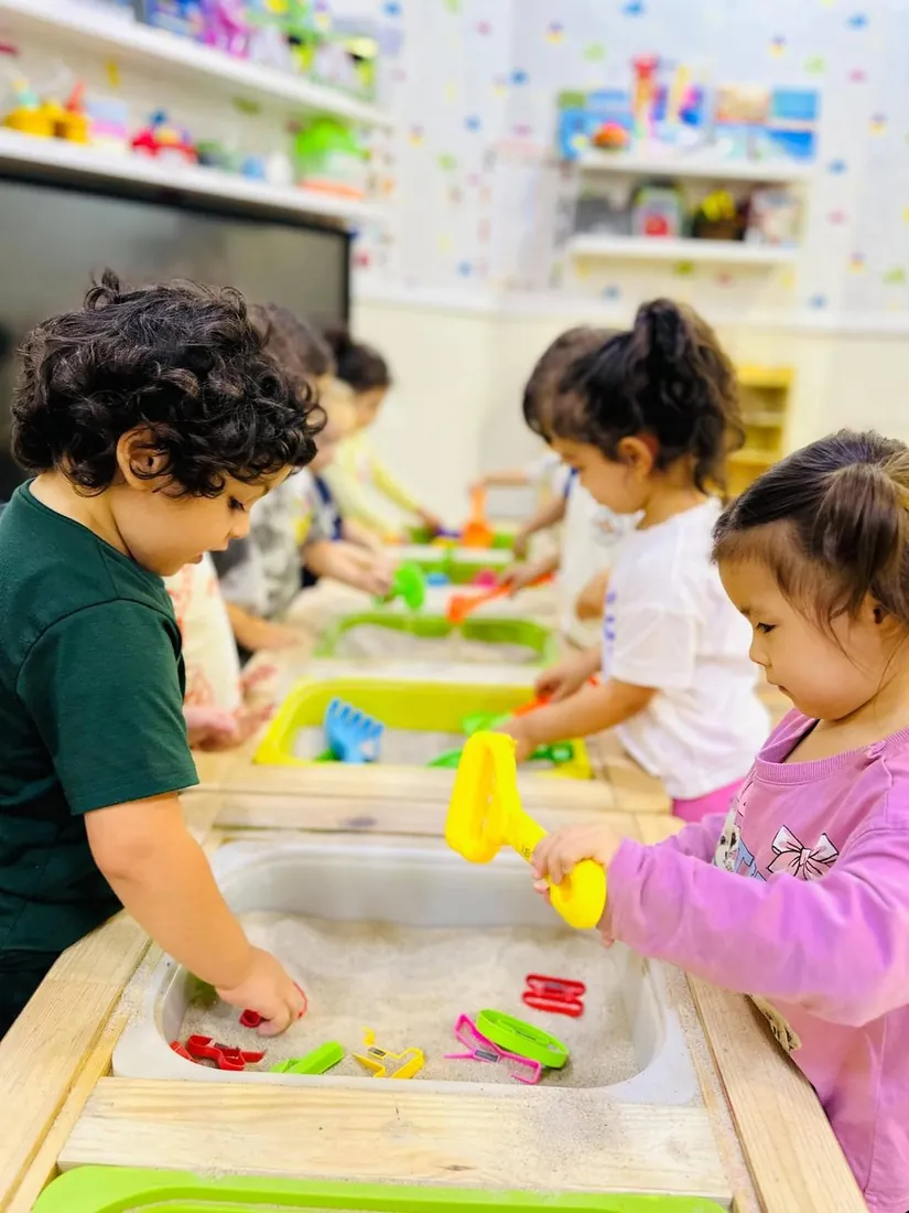 Children busy at the sand and sensory tables